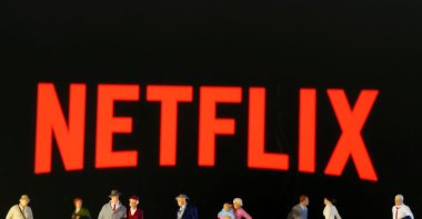 This illustration shows small toy figures in front of the Netflix logo. (Reuters Photo)