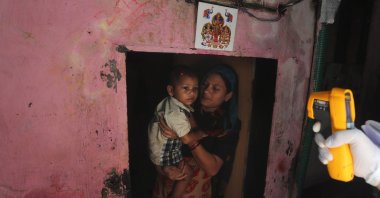 A health worker screens people for symptoms of COVID-19, Dharavi, Mumbai, Sept. 4, 2020. (AP Photo)