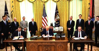 U.S. President Donald Trump signs a document as Kosovar Prime Minister Avdullah Hoti (R) and Serbian President Aleksandar Vucic (L)  sign an agreement on opening economic relations, in the Oval Office of the White House in Washington, D.C., on Sept. 4, 2020. (AFP Photo)