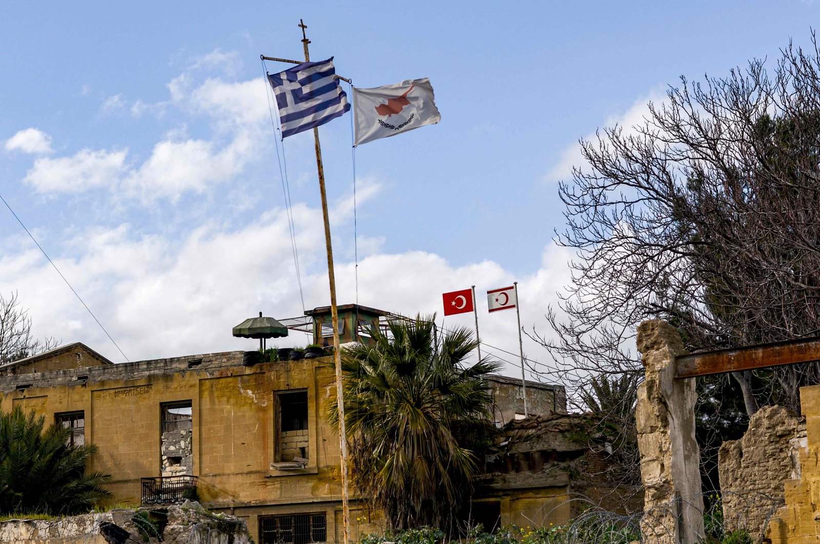 A  view of (L to R, foreground) the flags of Greece, the Greek Cypriot administration, (L to R, background) Turkey, and the Turkish Republic of Northern Cyprus (TRNC) flying on respective security outposts lying off both sides of the United Nations Buffer Zone in the old walled city of the divided capital Nicosia, Feb. 7, 2020. (AFP Photo)