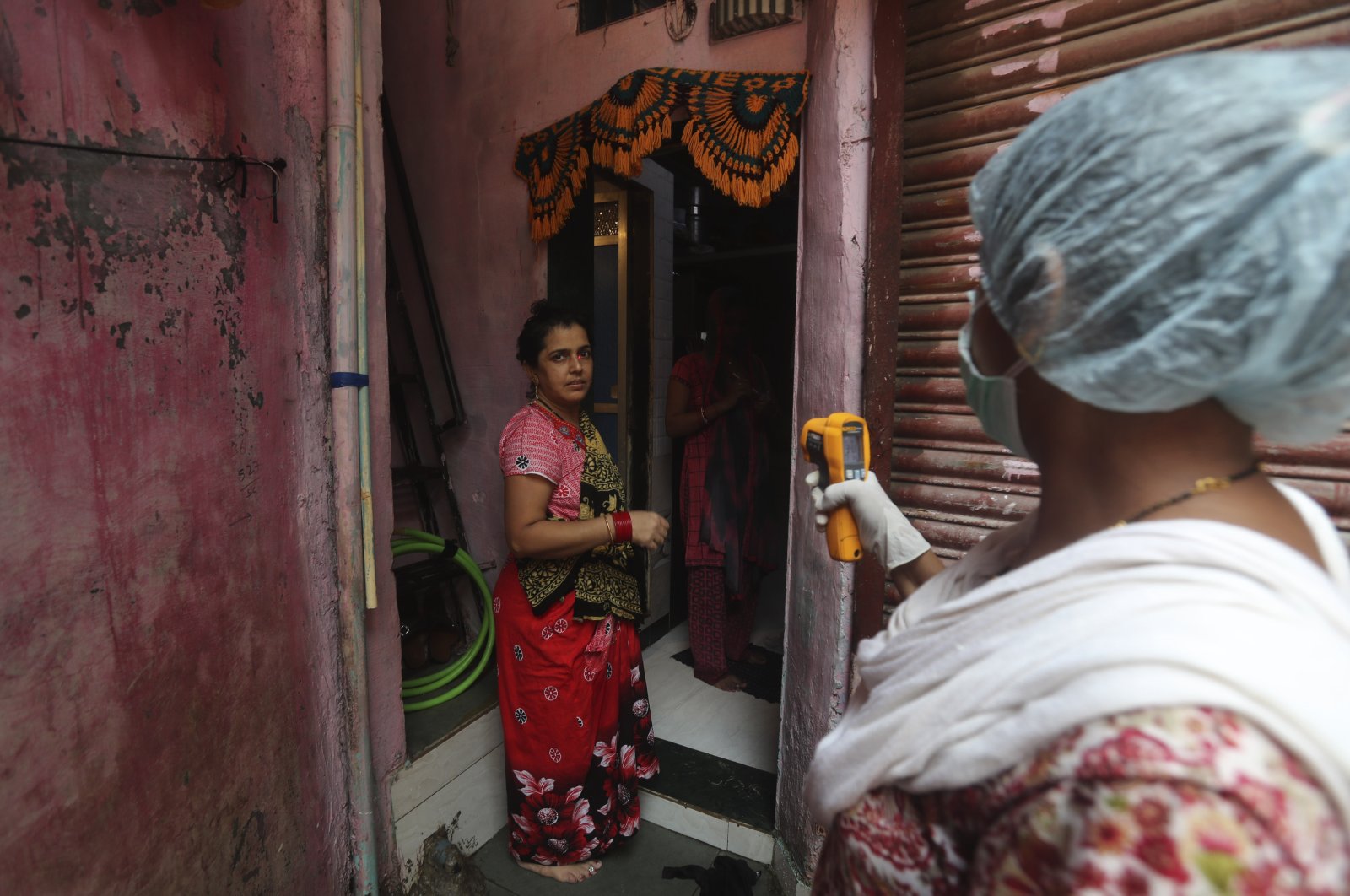 A health worker screens people for symptoms of COVID-19 in Dharavi, one of Asia's biggest slums, in Mumbai, India, Sept. 4, 2020. (AP Photo)