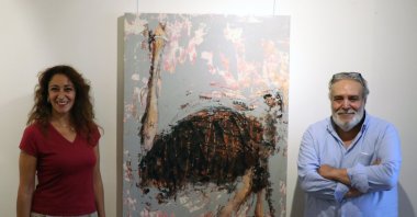 Artist İpek Mursaloğlu (L) and art director Adnan Al Ahmad pose with one of the ostrich paintings at the exhibition, Istanbul, Turkey, Sept. 4, 2020. (AA PHOTO)