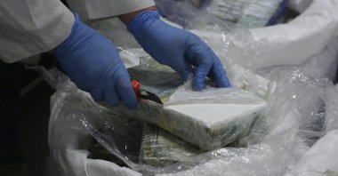 A member of the police opens a packet with cocaine as a large supply recently seized is displayed to the press at the Portuguese police headquarters in Lisbon, Jan. 8, 2020. (AP Photo)