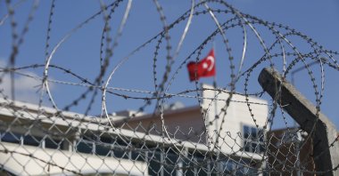 A Turkish flag behind the barbed-wire fence of the Silivri courthouse, in Silivri, outside Istanbul, Turkey, before the trial of Abdulkadir Masharipov, the main suspect in an attack that left 39 people dead at an Istanbul nightclub in 2017, Sept. 7, 2020. (AP Photo)