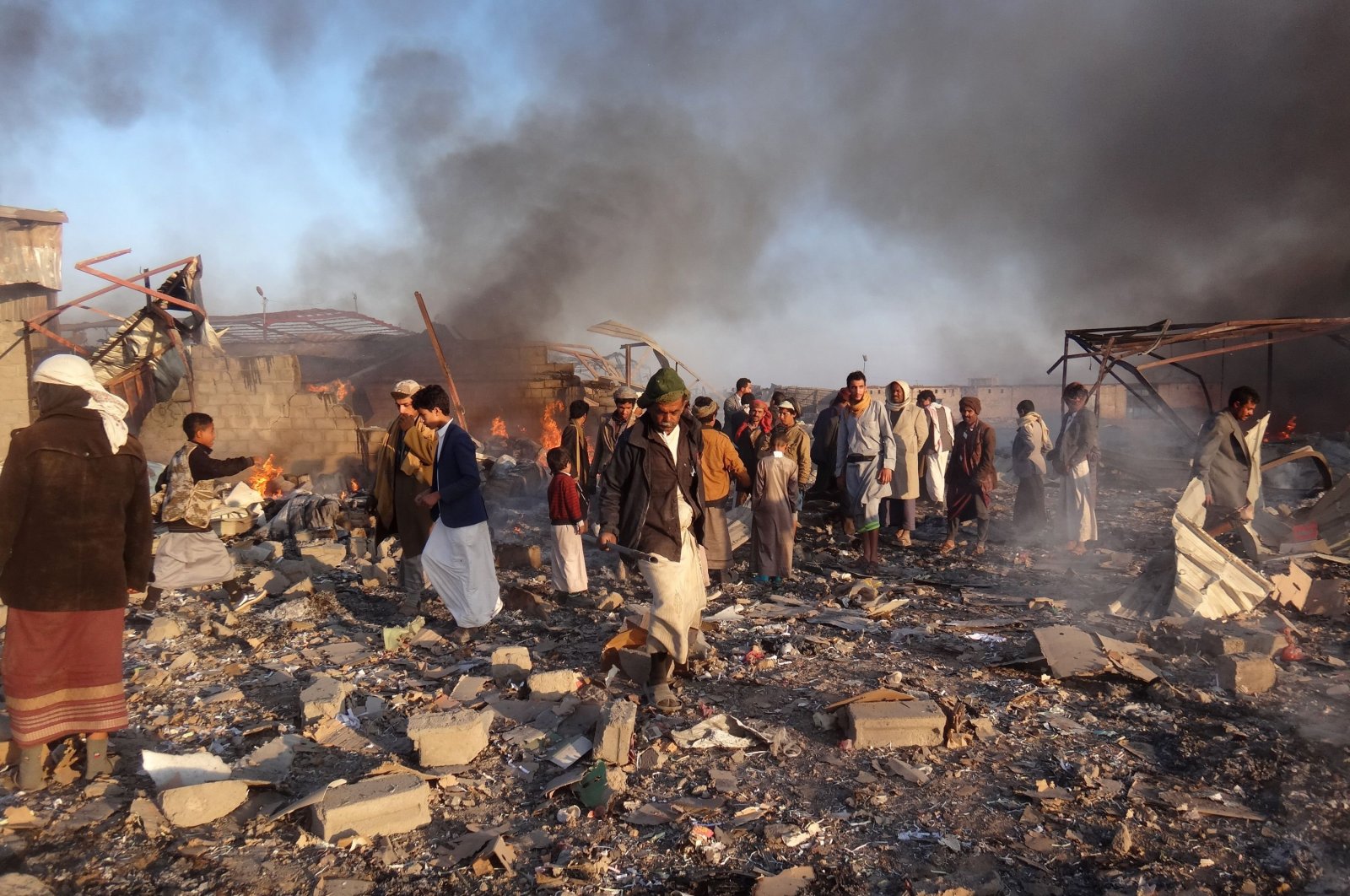 In this file photo taken on Jan. 6, 2018 smoke rises as Yemenis inspect the damage at the site of airstrikes in the northwestern Huthi-held city of Saada. (AFP Photo)