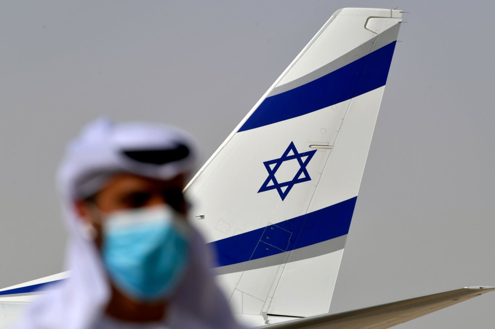 An Emirati official stands near the EI AI plane that carried a U.S.-Israeli delegation to the UAE following a normalization accord, marking the first-ever commercial flight from Israel to the UAE, Abu Dhabi, Aug. 31, 2020. (AFP Photo)