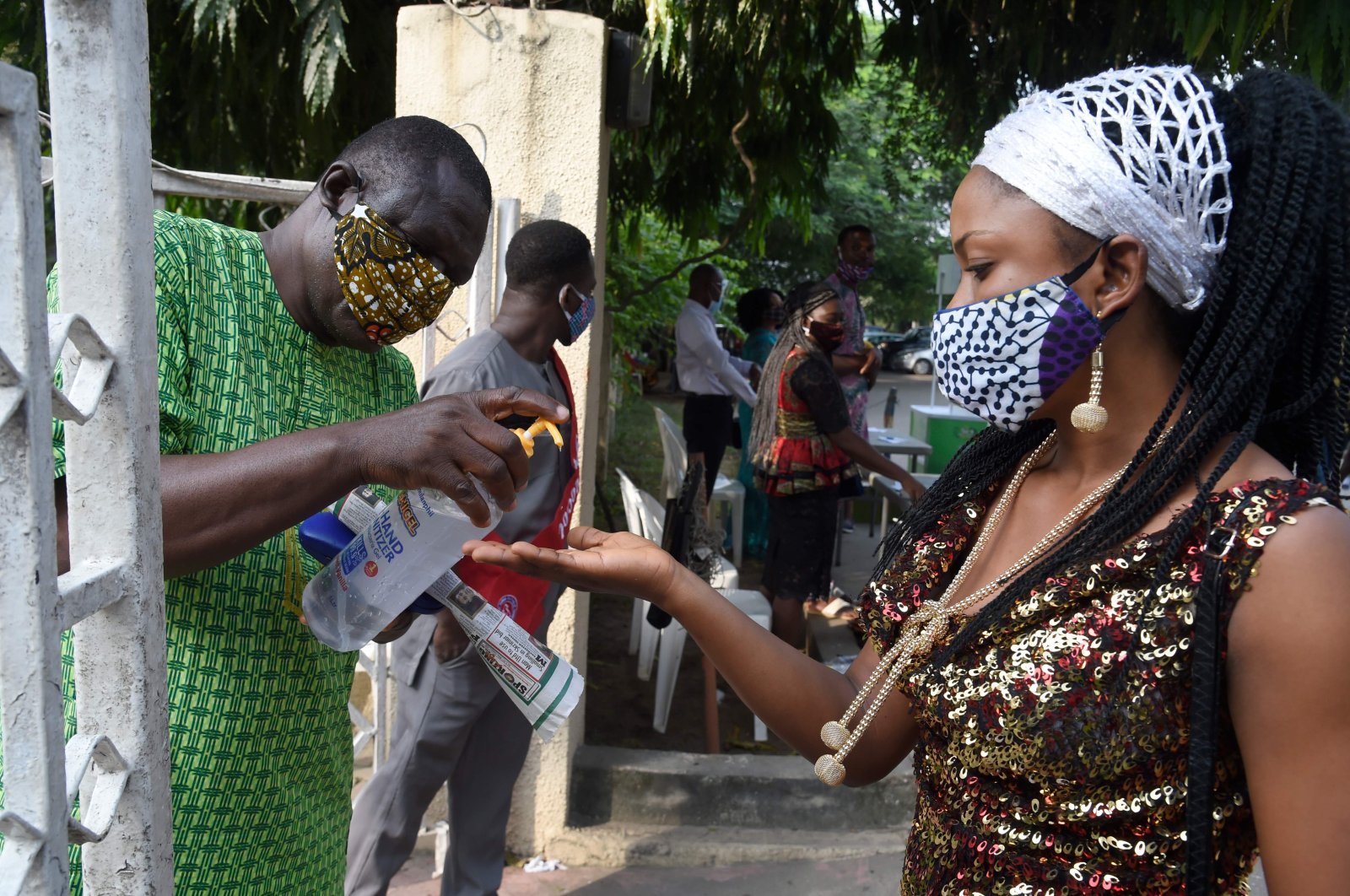 A woman wearing a face mask sanitizes her hands outside the Holy Cross Cathedral following the reopening of churches and lifting of restrictions on religious gatherings as a precaution to check the spread of COVID-19, in Lagos, Nigeria, Aug. 9, 2020. (AFP Photo)