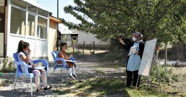 Gamze Arslan teaches a class of two students in their home's courtyard, in Van, eastern Turkey, Sept. 7, 2020. (AA Photo)