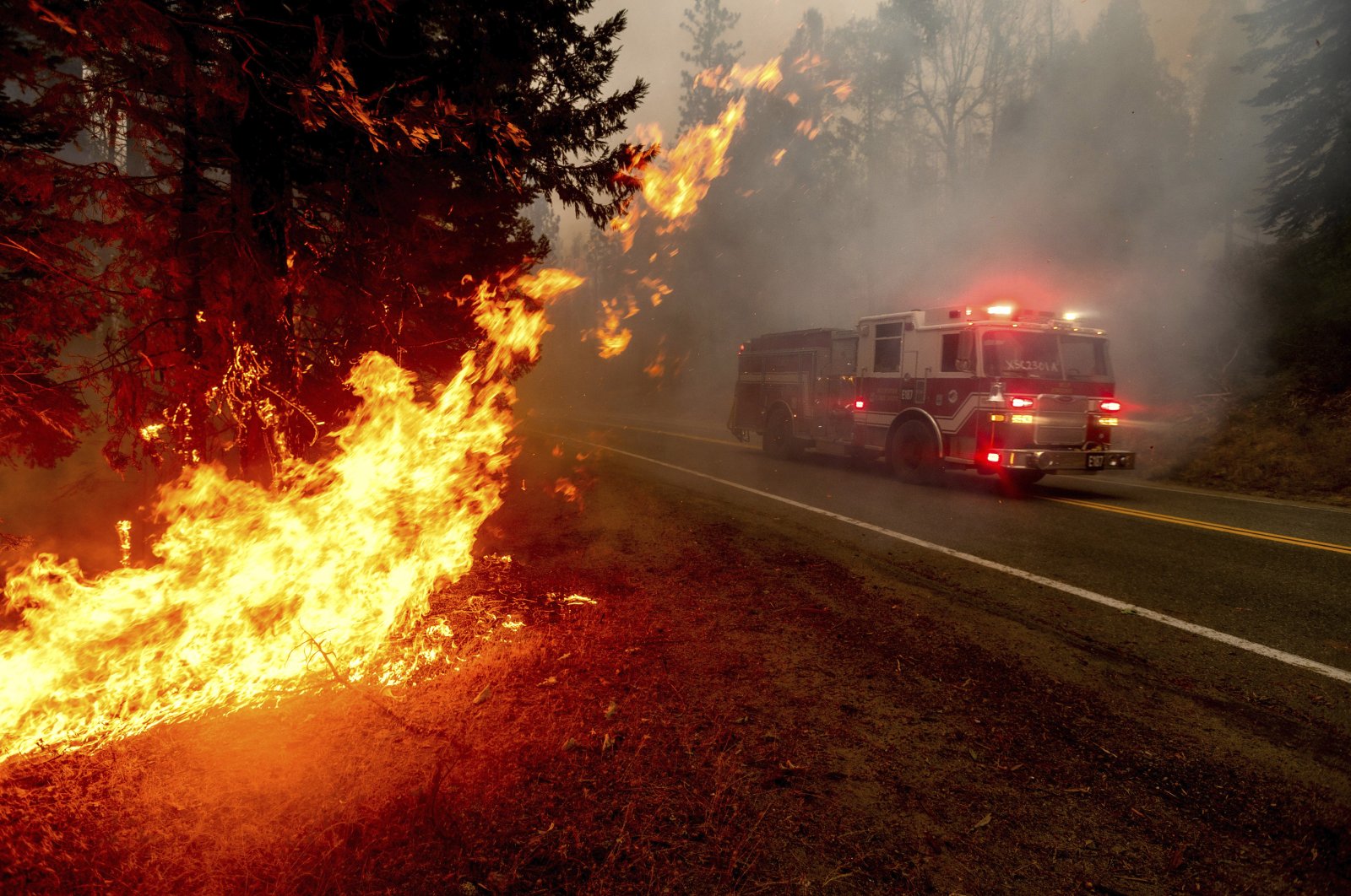 A firetruck drives along state Highway 168 while battling the Creek Fire in the Shaver Lake community of Fresno County, California, Sept. 7, 2020. (AP Photo)