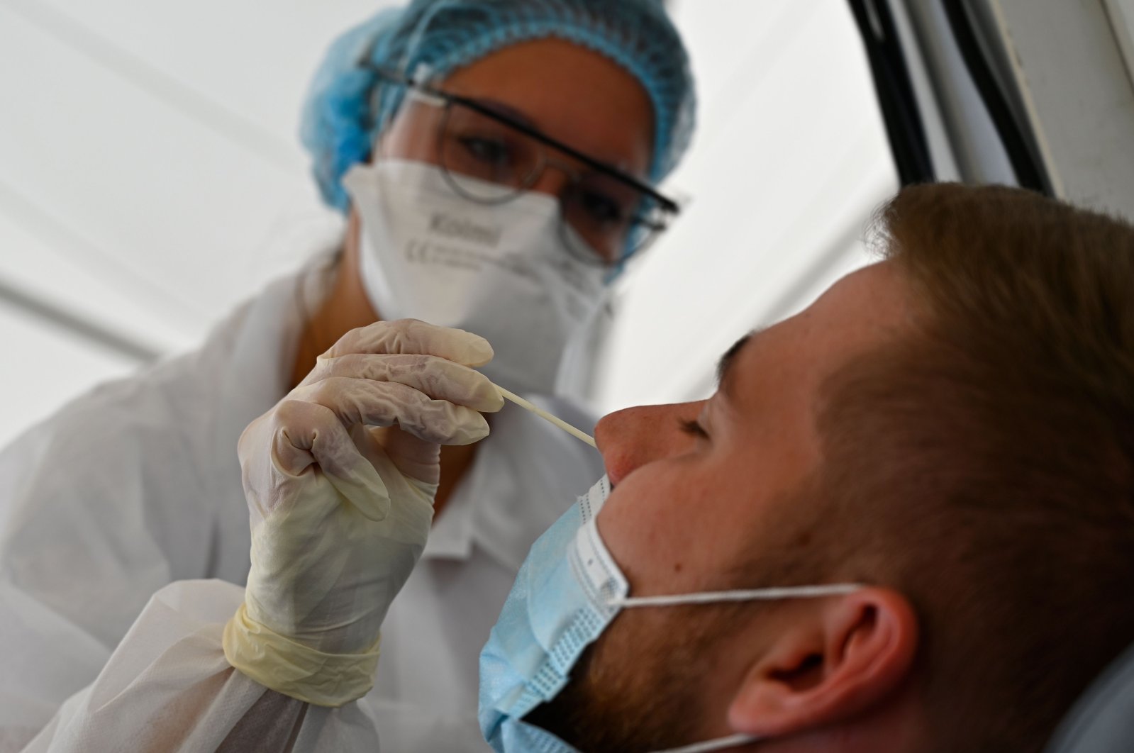 A health official collects a nasal swab sample from a man for a COVID-19 coronavirus test in a "COVID Drive" at the University Hospital Center (CHU) in Rennes, western France, Sept. 7, 2020. (AFP Photo)