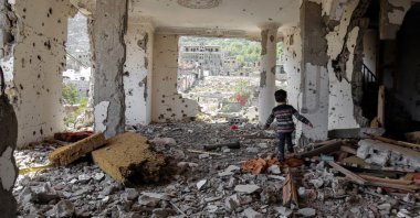 A Yemeni child walks in the rubble of a building that was destroyed by an air strike, Taez, March 18, 2018. (AFP Photo)