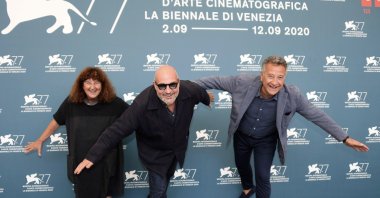 Italian filmmaker Gianfranco Rosi (C), Italian producers Donatella Palermo (L) and Paolo Del Brocco (R), pose at a photocall for "Notturno" during the 77th annual Venice International Film Festival, in Venice, Italy, Sept. 8, 2020. (EPA Photo)