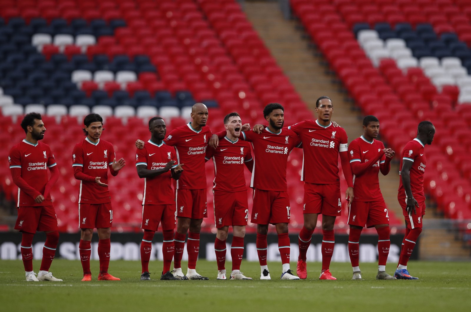 Liverpool players stand on the pitch during a match against Arsenal, in London, United Kingdom, Aug. 29, 2020. (AP Photo)