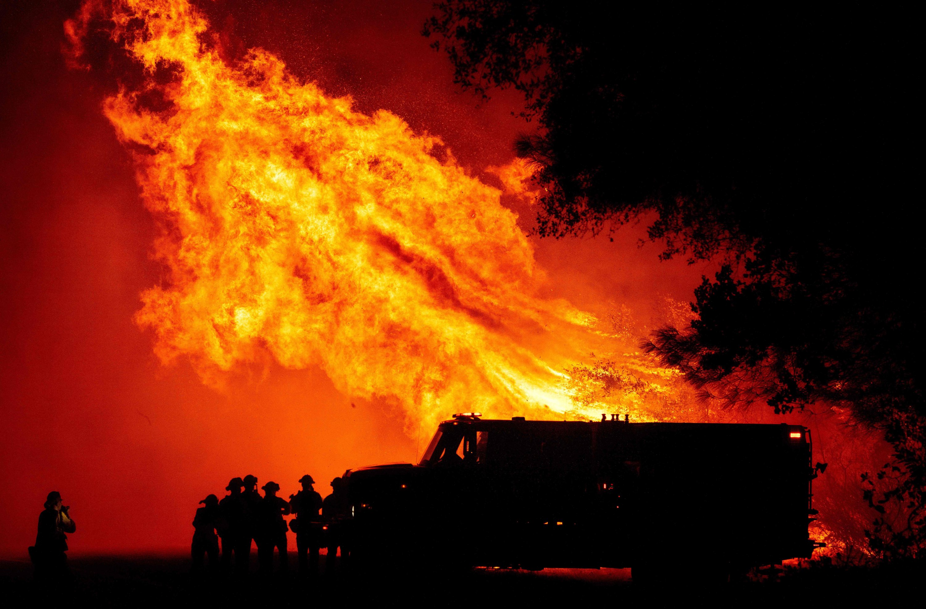 Butte county firefighters watch as flames tower over their truck during the Bear fire in Oroville, California, Sept. 9, 2020. (AFP Photo)