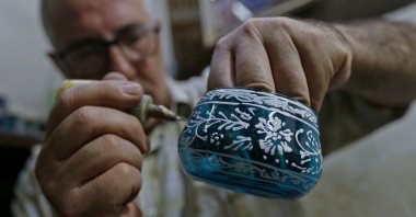 Syrian Mohamed al-Hallak, 62, forms a votive in a glass-blowing workshop in Syria's capital Damascus, Aug. 26, 2020. (AFP Photo)