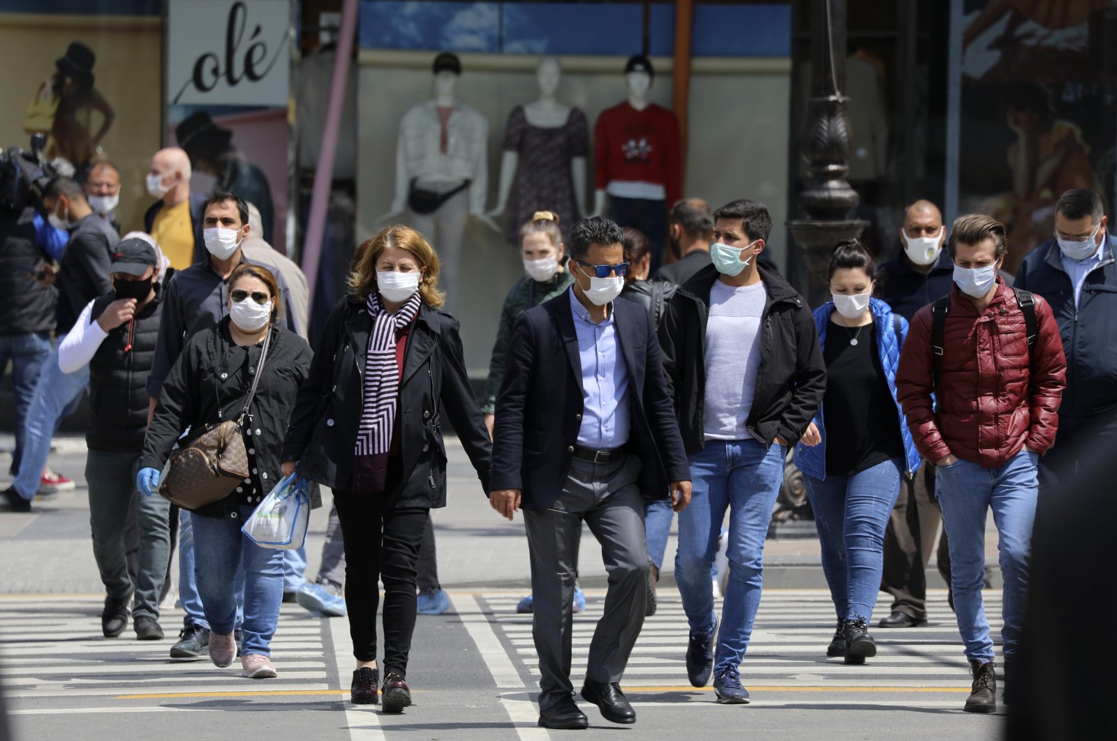 People wearing face masks for protection against the coronavirus walk in a busy street, in the capital Ankara, Turkey, May 5, 2020. (AP Photo)