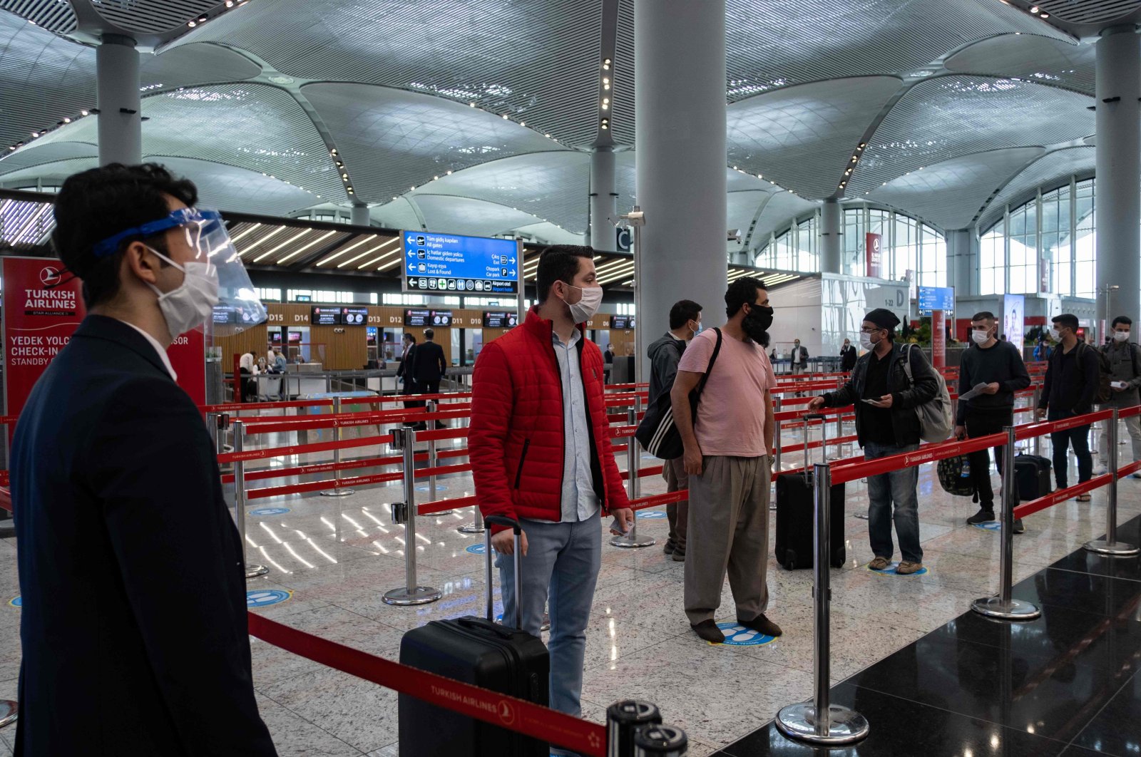 Passengers wearing protective face masks wait to be checked in at Istanbul Airport on the first day of the resumption of domestic flights after a pause due to the pandemic, in Istanbul, Turkey, June 1, 2020. (AFP Photo)