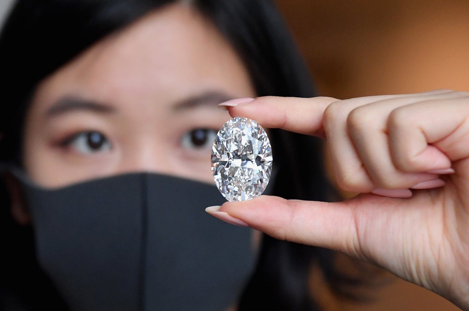 A Sotheby's employee holds a 102.39-carat flawless oval diamond during a media preview at Sotheby's, New York City, New York, U.S., Sept. 9, 2020. (AFP Photo)