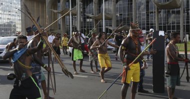 An indigenous man aims his arrow at police outside the National Congress during a protest for the demarcation of indigenous lands, Brasilia, Brazil, April 25, 2017. (AP Photo)