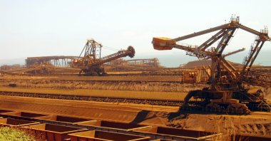 This file photo shows remote-controlled stackers and reclaimers moving iron ore to rail cars at Rio Tinto's Port Dampier operations in Western Australia's Pilbara region, March 4, 2010. (AFP Photo)