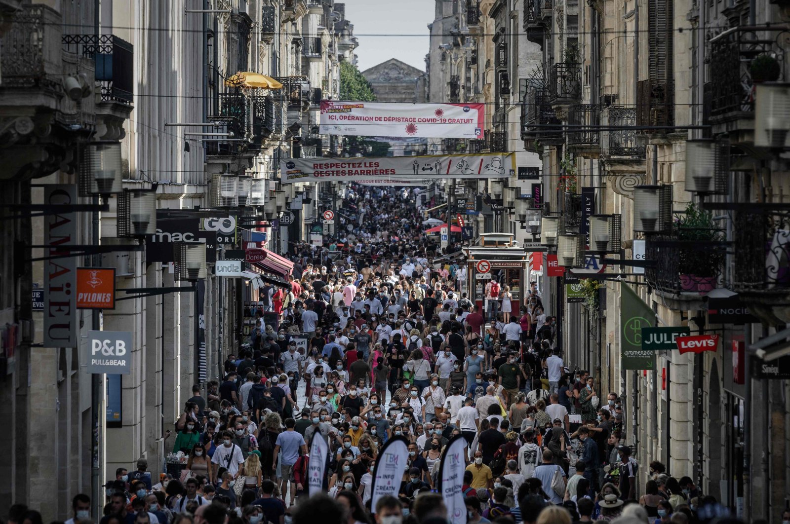 Pedestrians, some of them wearing protective face masks, walk along a street lined with shops, Bordeaux, France, Sept. 5, 2020. (AFP Photo)