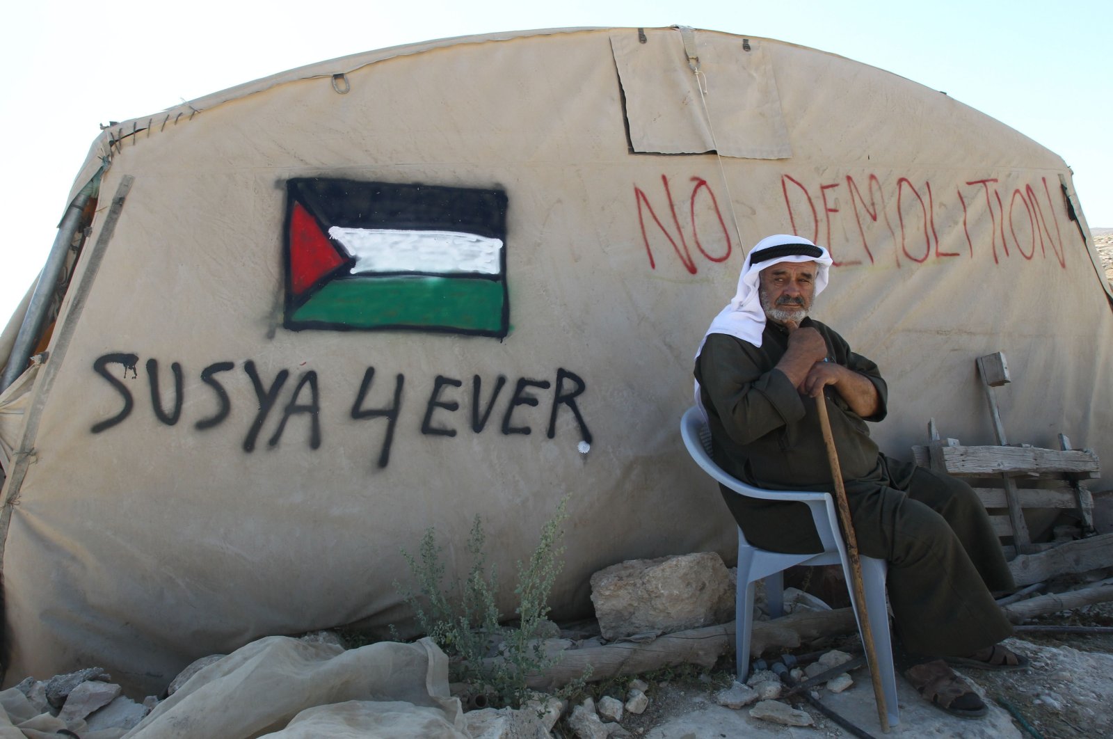A Palestinian man sits outside his tent in the southern West Bank village of Susya, July 22, 2015. (AFP Photo)