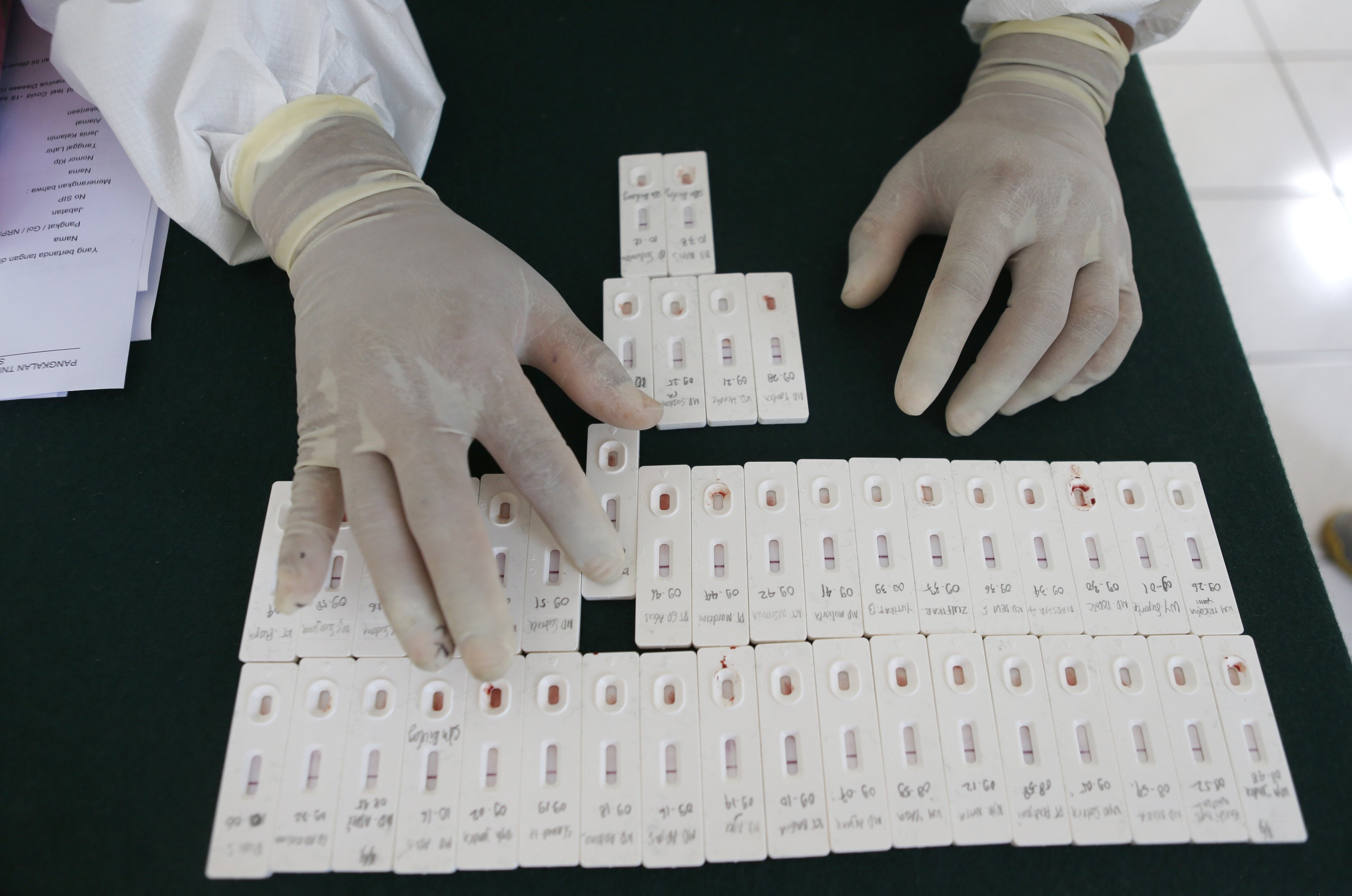 A health worker organizes coronavirus antibody test results at an office in Bali, Indonesia, Sept. 11, 2020. (AP Photo)