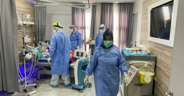 Hamza Abdulrahman Jelwal, a supervising nurse wearing a protective suit, and his teammates care for a patient infected with the coronavirus disease (COVID-19), at a quarantine center, in Misrata, Libya September 7, 2020. Picture taken September 7, 2020. (Reuters Photo)