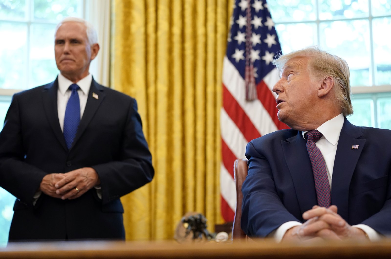 U.S. President Donald Trump looks toward Vice President Mike Pence in the Oval Office of the White House, Washington, D.C., Sept. 11, 2020. (AP Photo)