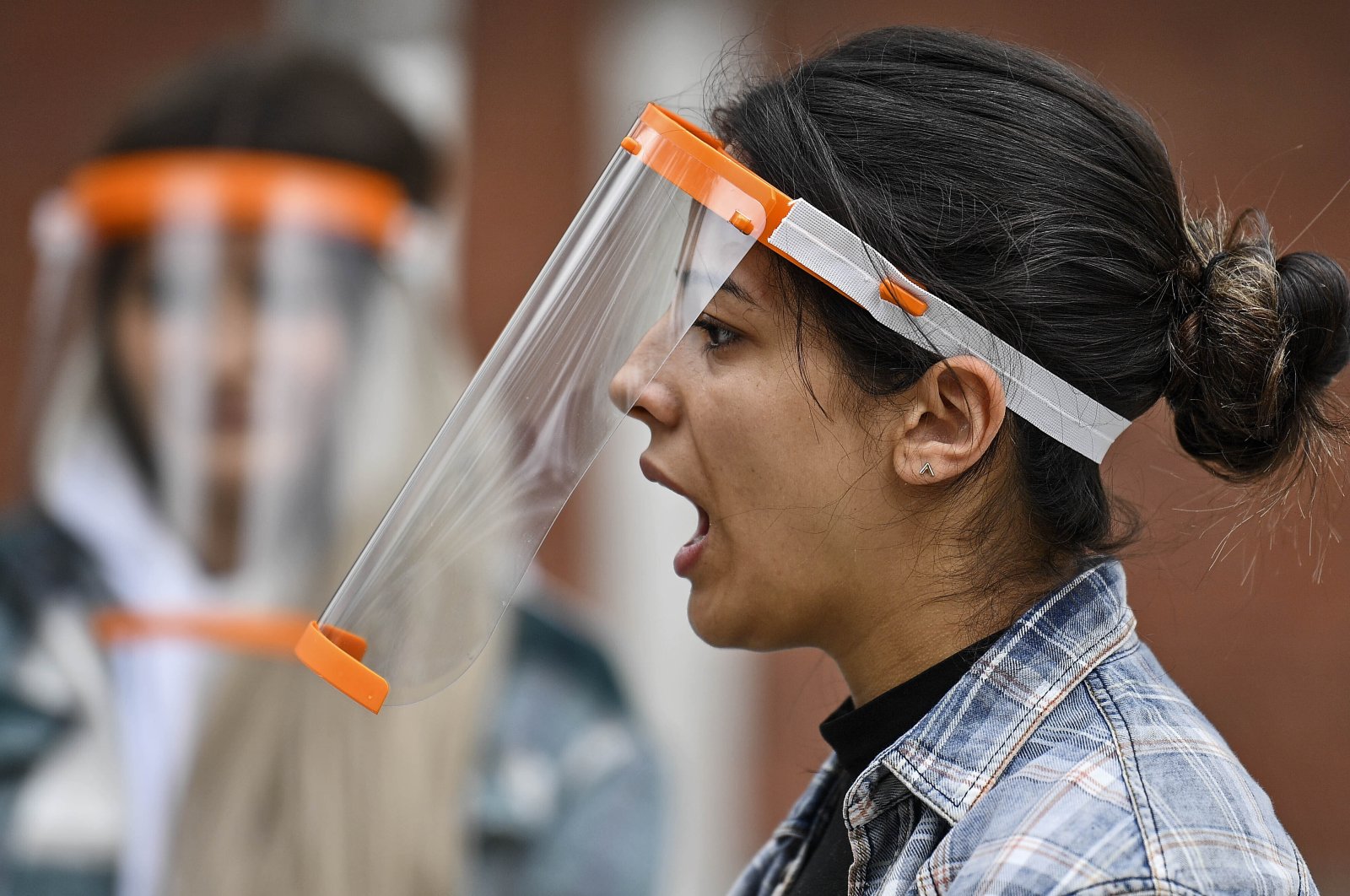A student talks behind a face shield at a school in Cologne, Germany, May 25, 2020. (AP Photo)