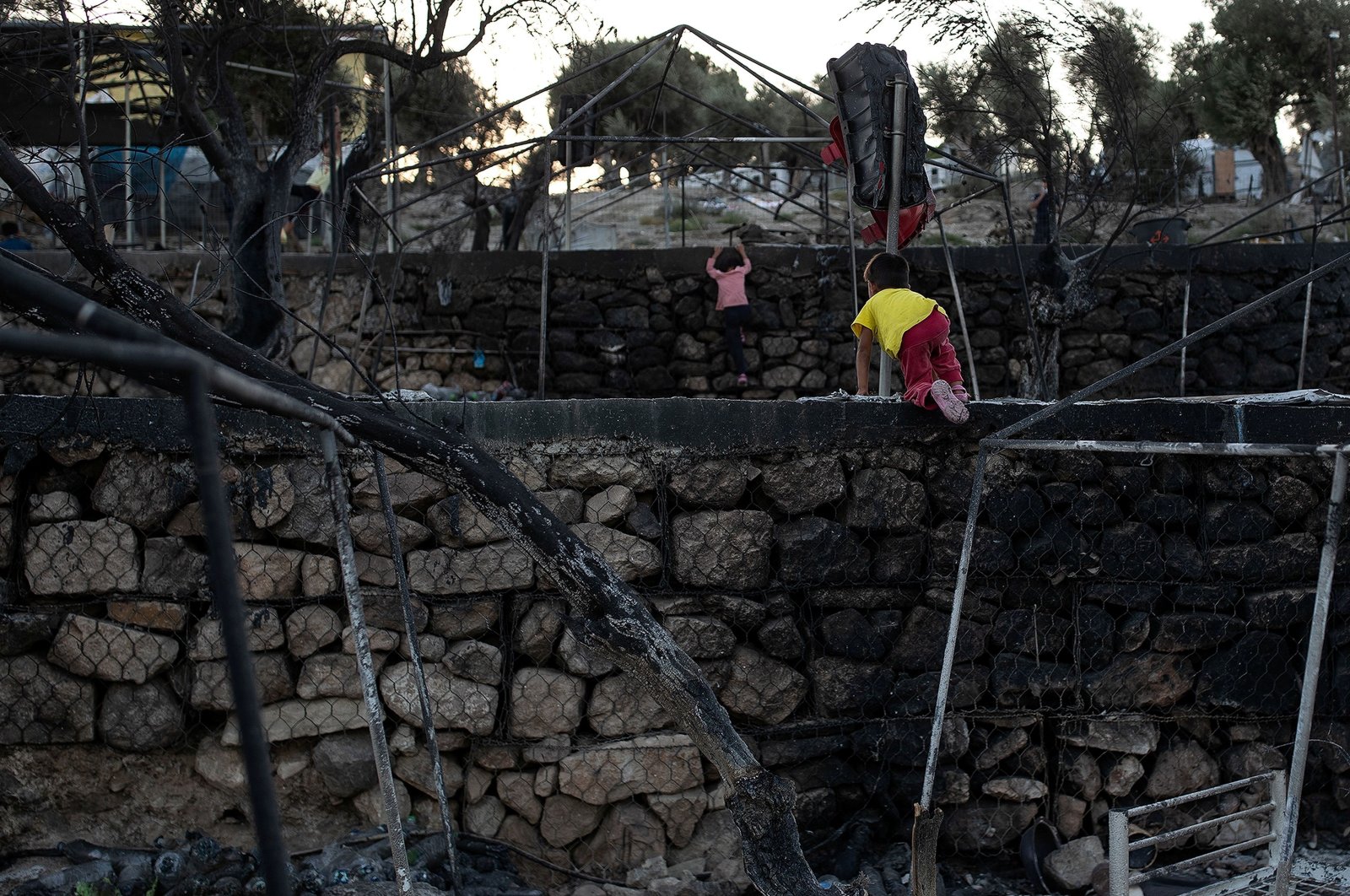 Children climb walls among burnt tents at the destroyed Moria camp for refugees and migrants, on the island of Lesbos, Greece, Sept. 14, 2020. (Reuters Photo)