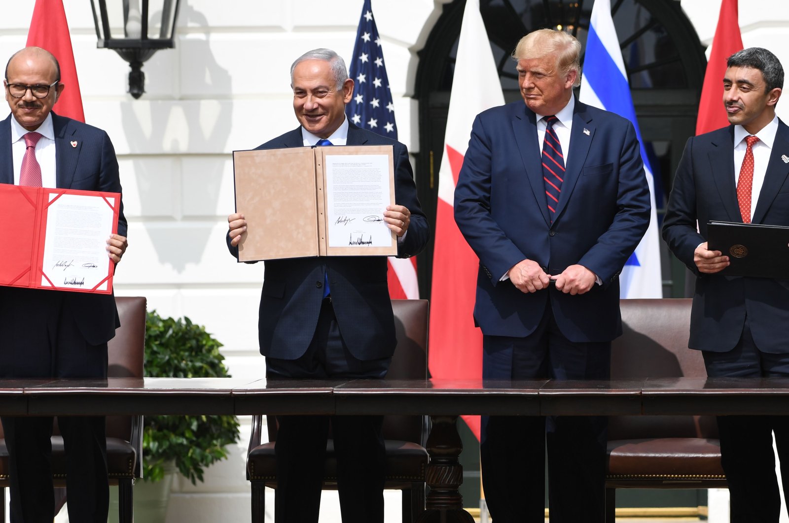 Bahraini Foreign Minister Abdullatif al-Zayani (L), Israeli Prime Minister Benjamin Netanyahu (CL), US President Donald Trump (CR) and UAE Foreign Minister Abdullah bin Zayed Al-Nahyan hold up documents after participating in the signing of the Abraham Accords at the White House in Washington, Sept. 15, 2020. (AFP Photo)