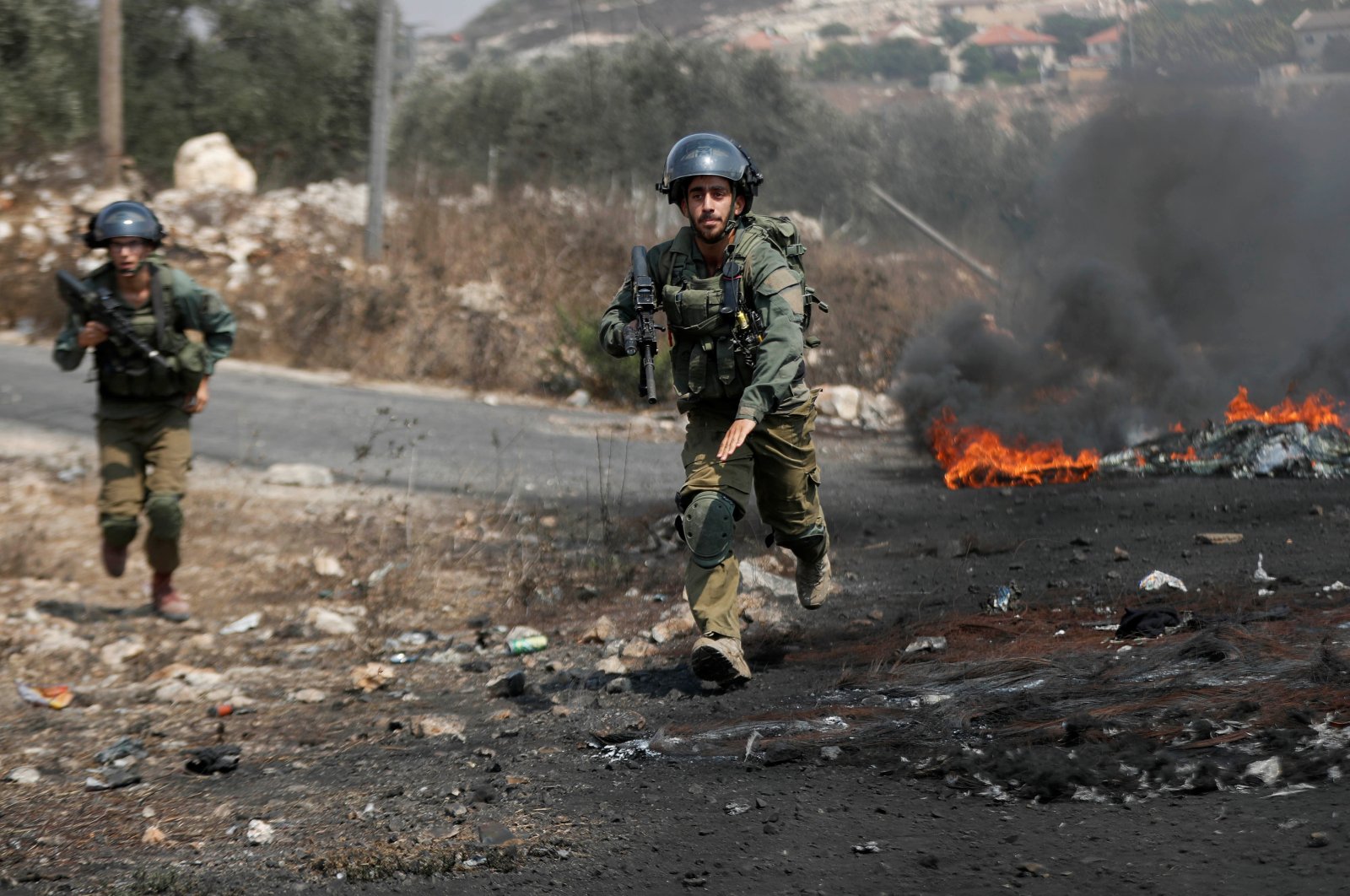 Israeli soldiers run toward demonstrators during a Palestinian protest against Israeli violence, in Kafr Qaddum town in the Israeli-occupied West Bank, Sept.11, 2020. (Reuters Photo)