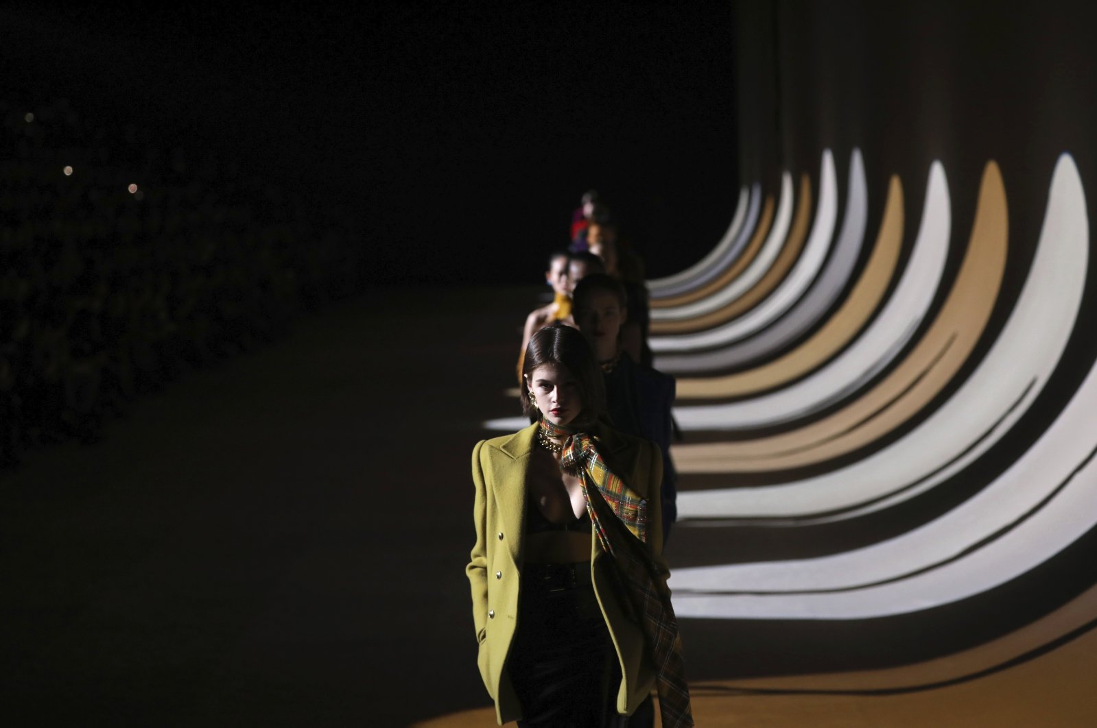 In this Feb. 25, 2020 file photo, model Kaia Gerber leads other models as they wear creations for the Saint Laurent fashion collection during Women's fashion week Fall/Winter 2020/21 presented in Paris. (AP Photo)