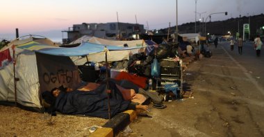 Migrants sleep outside their tents as they remain camped out on a road leading from Moria to the capital of Mytilene, Lesbos, Sept. 17, 2020. (AP Photo)