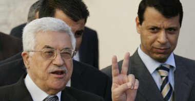 Palestinian Authority President Mahmoud Abbas (L) flashes the peace sign as Mohammed Dahlan looks on in the West Bank town of Ramallah, Dec. 18, 2006. (AP Photo)