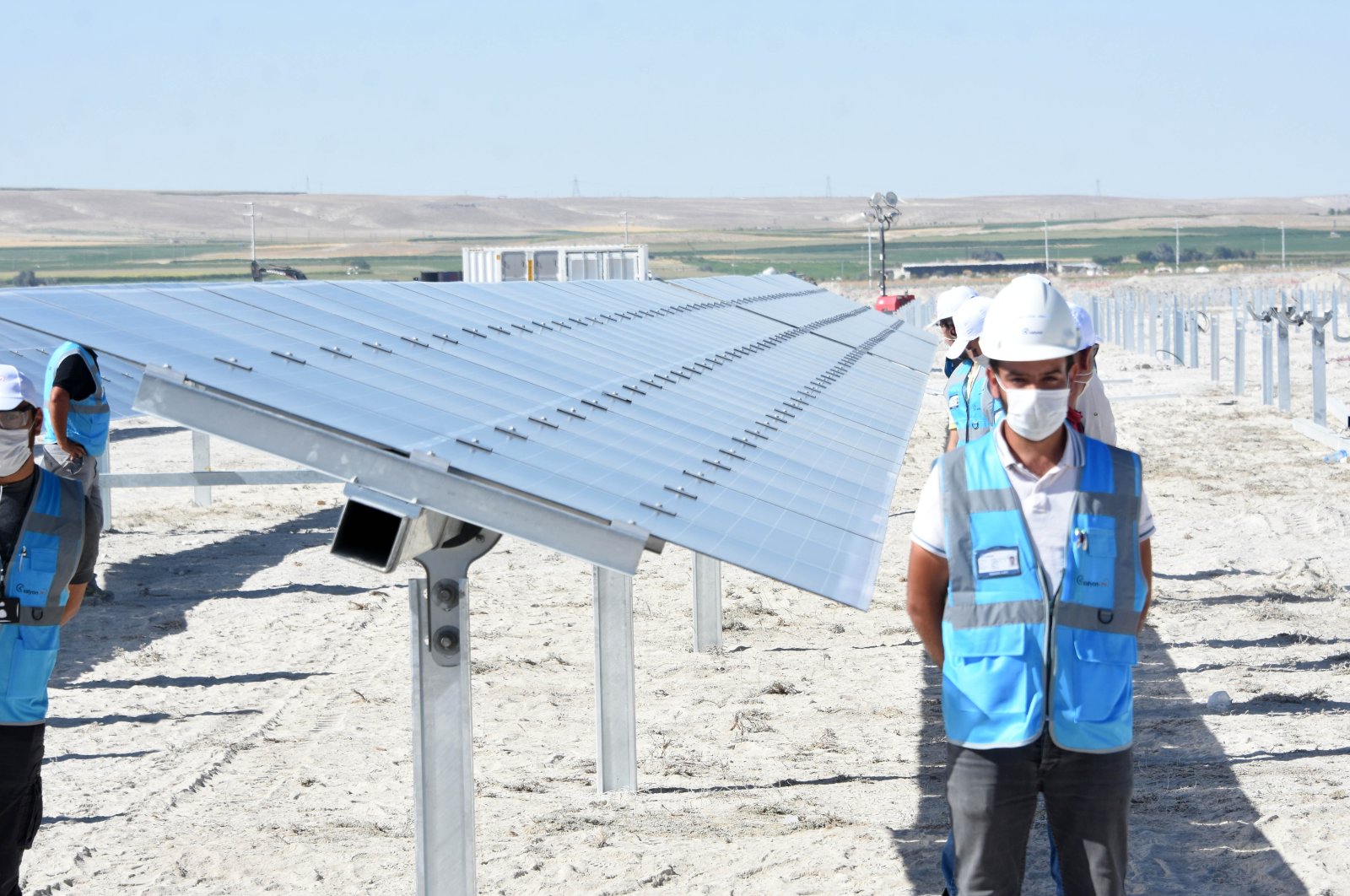 Workers stand by the solar panels in central Turkey's Karapınar SSP during the inauguration ceremony on Aug. 19, 2020. (DHA Photo)