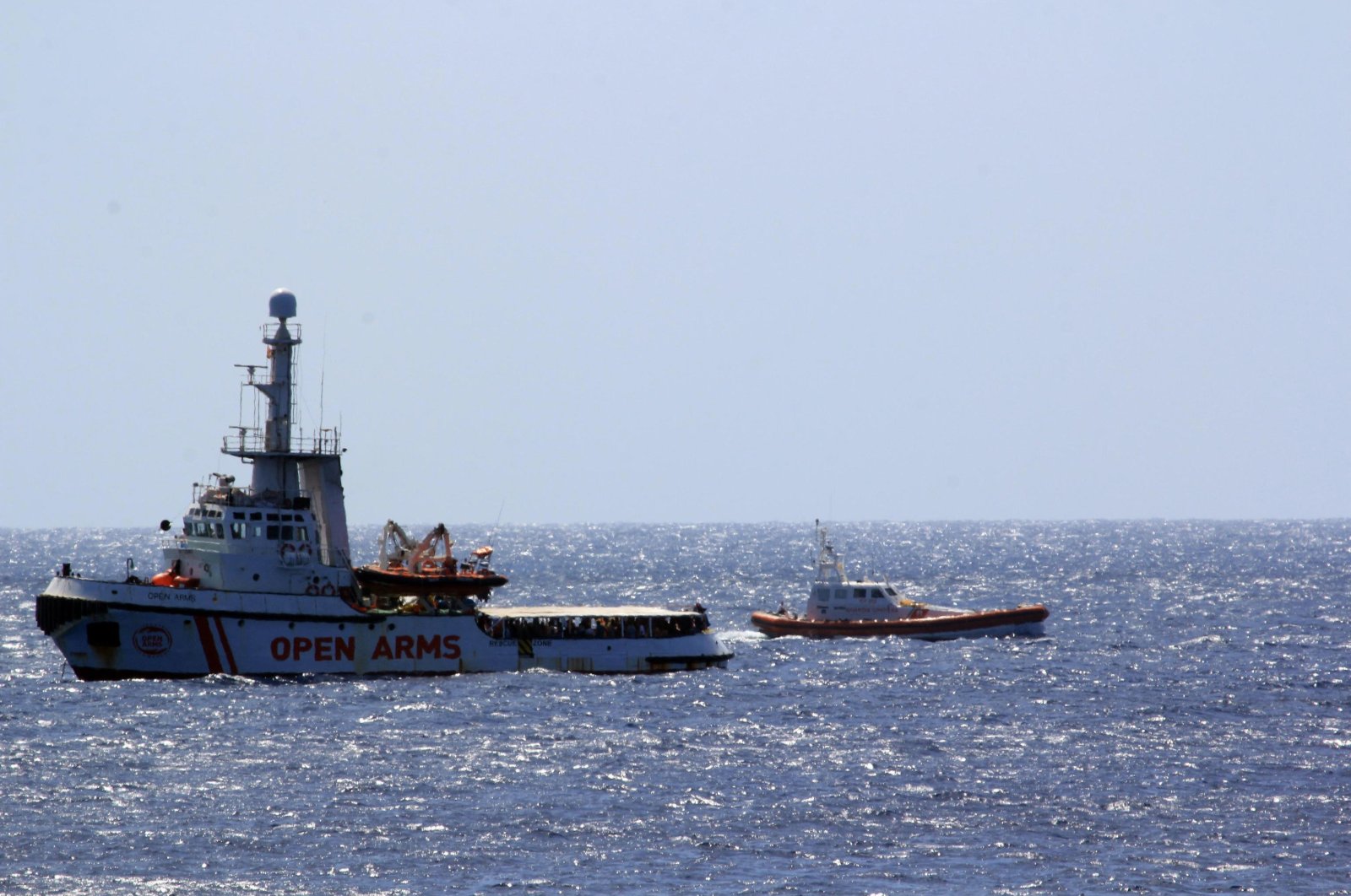 The Open Arms Spanish humanitarian boat with 147 migrants (L) is monitored by an Italian coast guard vessel as it sails off the coast of the Sicilian island of Lampedusa, southern Italy, Aug. 15, 2019. (AP Photo)