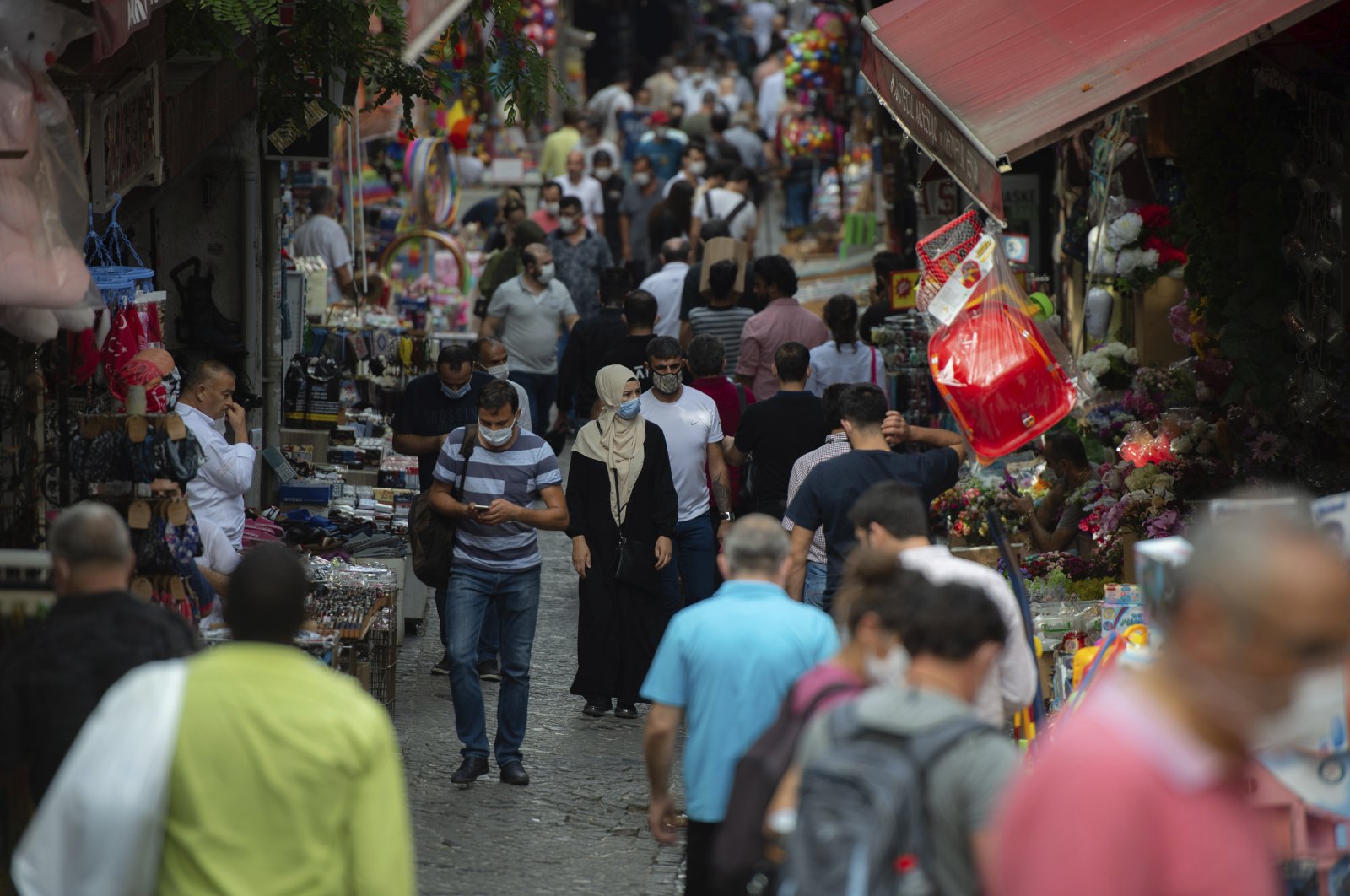 People wearing masks for protection against the spread of coronavirus, walk in a market in Istanbul, Friday, Sept. 11, 2020. (AP Photo)