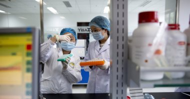 Employees work in a research and development lab of Beijing Applied Biological Technologies, a firm which is developing COVID-19 molecular diagnostic test kits, during a government-organized tour for journalists in Beijing, China, May 14, 2020. (AP Photo)