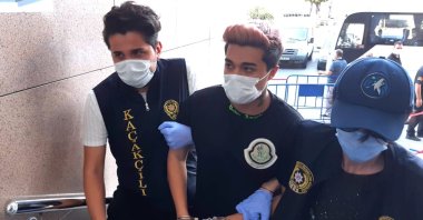 Police officers escort Meriç İzgi (C) to the courthouse in Istanbul, Turkey, Sept. 18, 2020. (AA Photo)