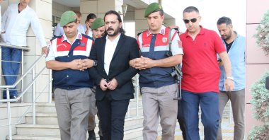 Writer Emrah Serbes is escorted out of a court by gendarmerie officers in Izmir, Turkey, in this undated photo. (IHA Photo)