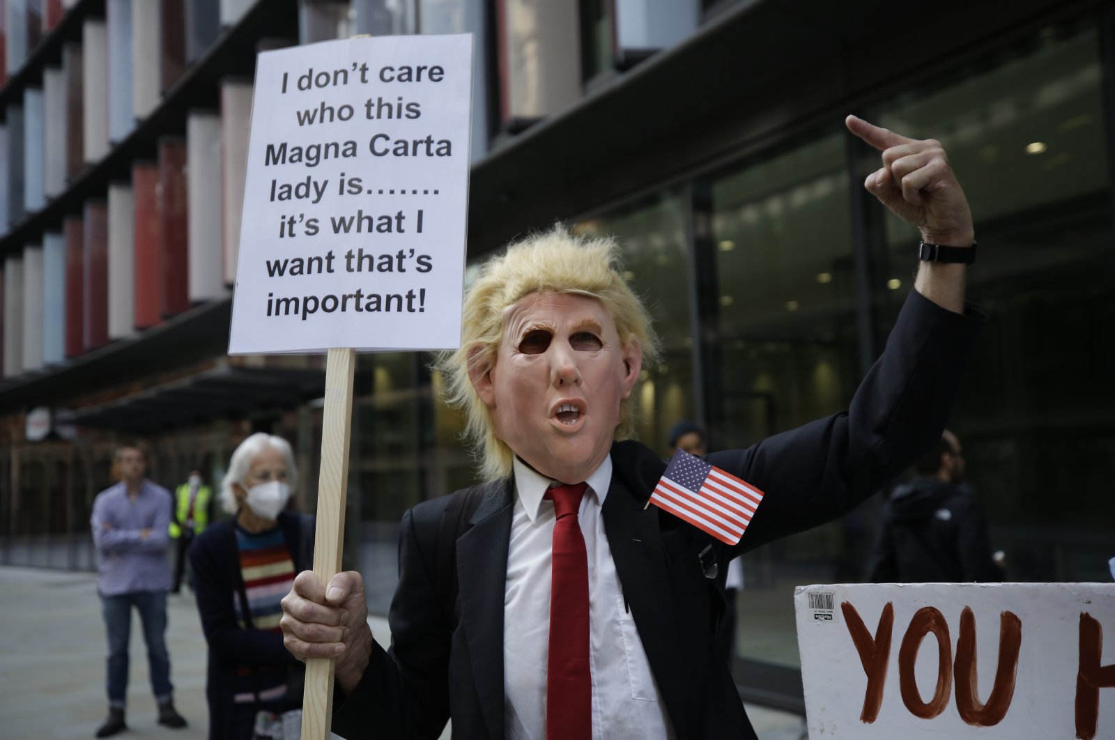 A supporters of WikiLeaks founder Julian Assange wearing a mask portraying U.S. President Donald Trump takes part in a protest outside the Central Criminal Court, the Old Bailey, in London, Britain, Sept. 14, 2020. (AP Photo)