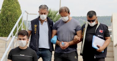 Police officers detain Tayfun Demir, (C) in Muğla, Turkey, Sept. 20, 2020. (IHA Photo)