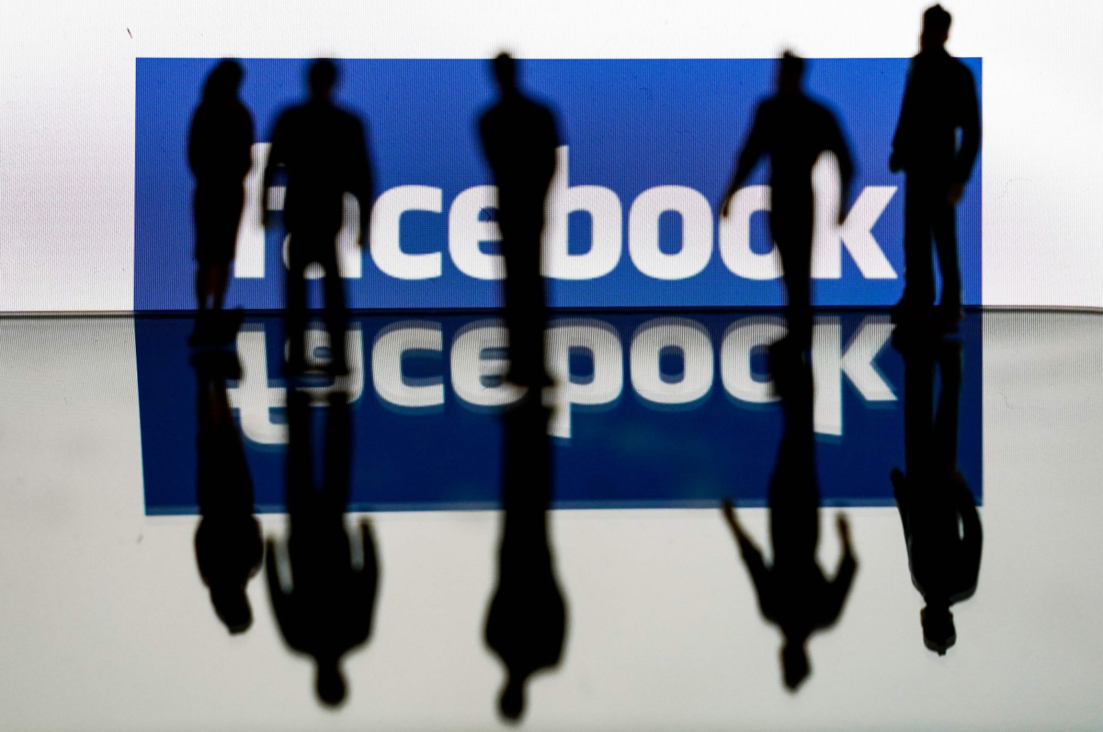 Silhouettes are seen in front of the logo of U.S. social media giant Facebook in Brussels, Feb. 14, 2020. (AFP Photo)