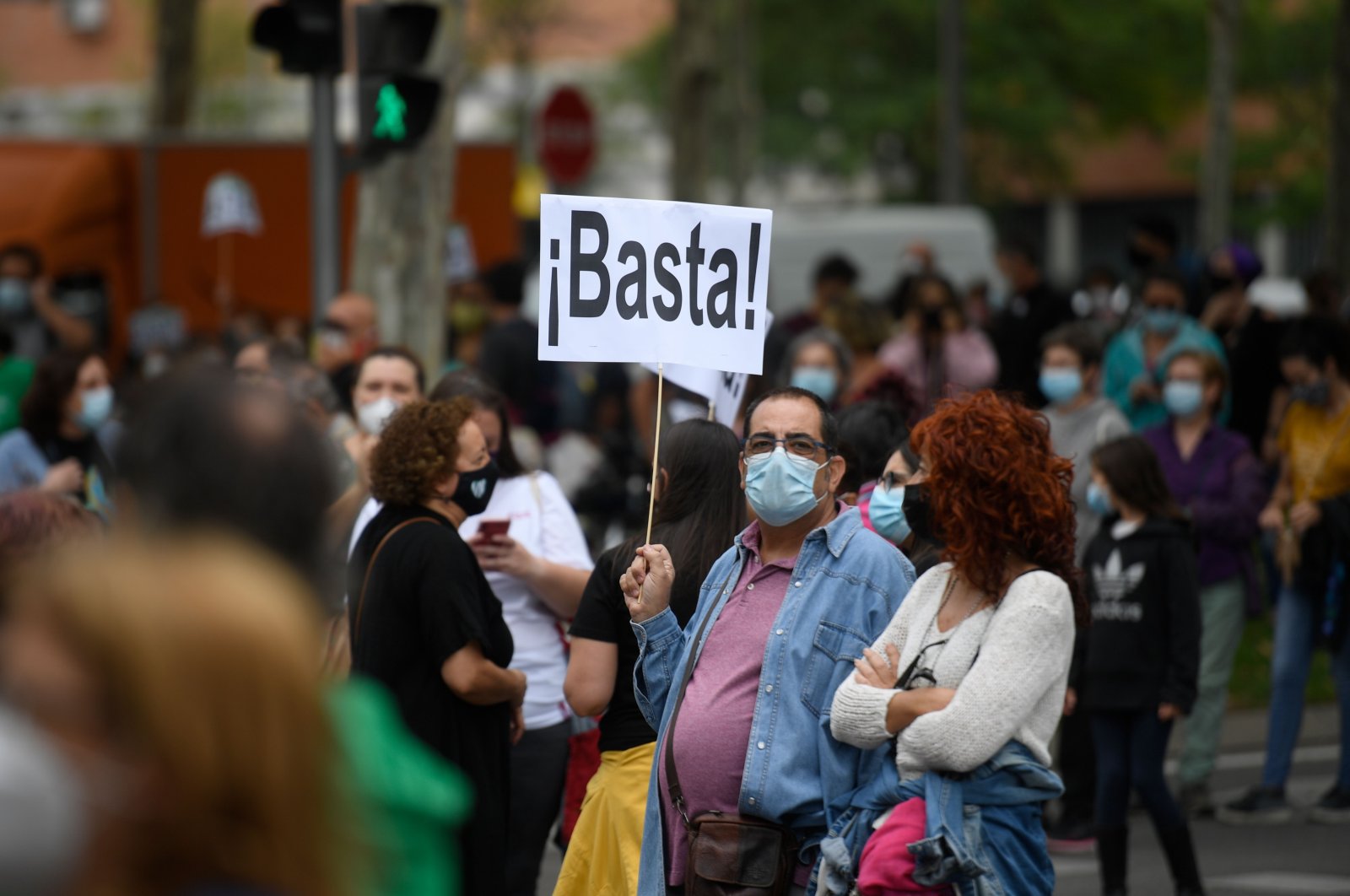 A man holds a placrad reading "Enough" during a demonstration at the Vallecas neighborhood in Madrid, on September 20, 2020, to protest against the new restrictive measures announced by regional authorities. (AFP Photo)