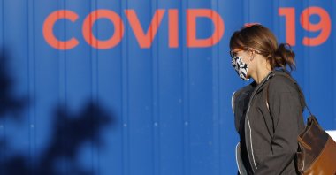 A woman wearing a face mask walks to get tested for COVID-19 at a sampling station in Prague, Czech Republic, Sept. 18, 2020. (AP Photo)