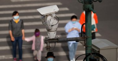 A CCTV security surveillance camera overlooks a street as people walk following the spread of COVID-19 in Beijing, China, May 11, 2020. (Reuters Photo)
