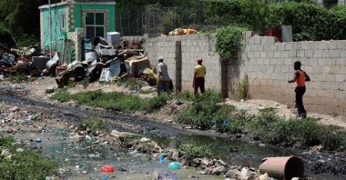 People walk along open sewers and scattered rubbish in Yemen's third city of Taiz, Sept. 19, 2020. (AFP Photo)