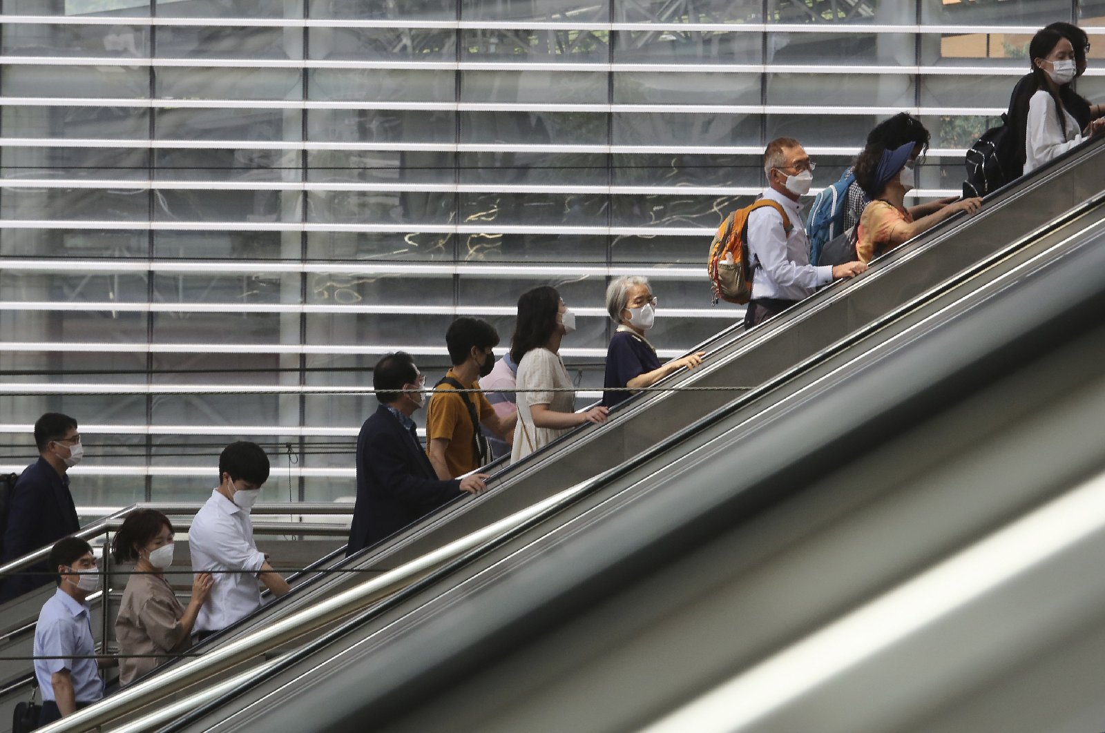 People wearing face masks to help protect against the spread of the coronavirus ride an escalator as they arrive at the Seoul Railway Station in Seoul, South Korea, Aug. 24, 2020. (AP Photo)